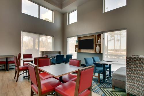 a dining room with a table and chairs and windows at Holiday Inn Express Hotel & Suites Jacksonville North-Fernandina, an IHG Hotel in Yulee