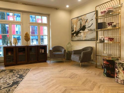 a living room with two chairs and a table and windows at Arthotel ANA Fleur in Paderborn