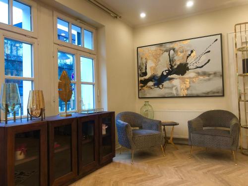 a living room with two chairs and a painting on the wall at Arthotel ANA Fleur in Paderborn