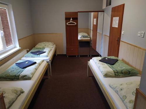 a group of three beds in a room at Penzion Zátiší in Komorní Lhotka
