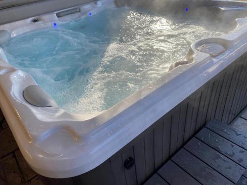 a jacuzzi tub with blue water in it at Alpenblick Nahe München mit Outdoor Whirlpool - 21 Min von München mit Zug in Aßling