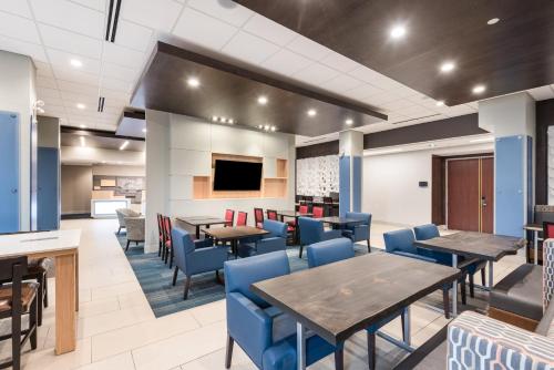 a dining room with tables and blue chairs at Holiday Inn Express Hotel & Suites Milton by IHG in Milton