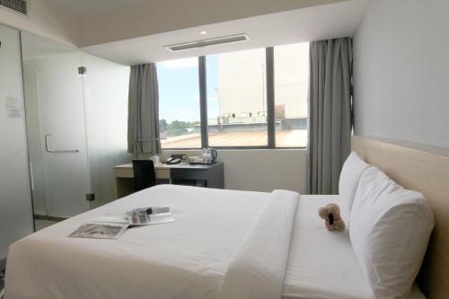 Cette chambre comprend un lit blanc et une fenêtre. dans l'établissement Pacific Express Hotel Central Market Kuala Lumpur, à Kuala Lumpur