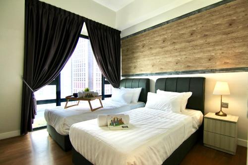 クアラルンプールにあるAnggun Residence By Sleepy Bearのベッド2台と大きな窓が備わるホテルルームです。