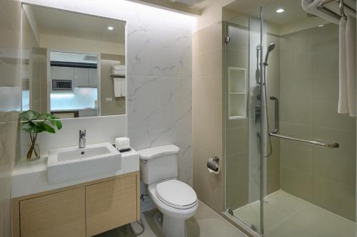 a bathroom with a toilet sink and a shower at PARKROYAL Suites Bangkok in Bangkok