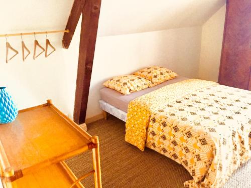a small bedroom with a bed and a table at Chambres chez l'habitant et table d'hôtes Crocq "le vieil hôtel" in Crocq