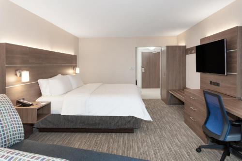a hotel room with a bed and a desk and a tv at Holiday Inn Express & Suites Downtown Ottawa East by IHG in Ottawa