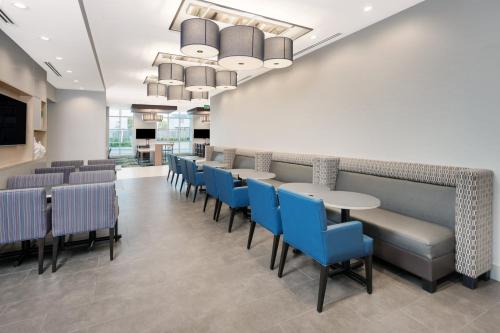 a dining room with tables and blue chairs at Holiday Inn Express & Suites Downtown Ottawa East by IHG in Ottawa
