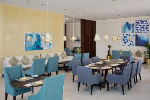 a dining room with tables and blue chairs at Staybridge Suites Al Khobar by IHG in Al Khobar