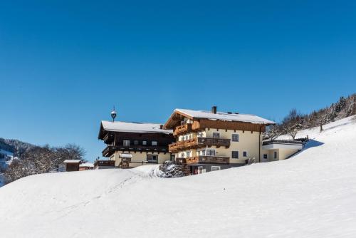a building on top of a snow covered hill at Ganzenhubhof in Goldegg