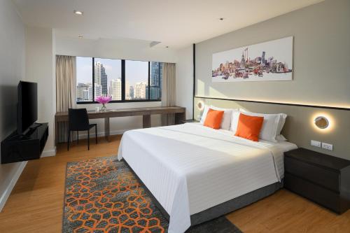 A bed or beds in a room at PARKROYAL Suites Bangkok - Former Phachara Suites Bangkok