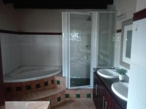 y baño con 2 lavabos y bañera. en MixoSunrise Guesthouse & Spa, en Pretoria