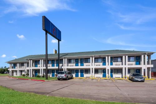 a large white building with cars parked in a parking lot at Motel 6 Irving - Loop 12 in Irving
