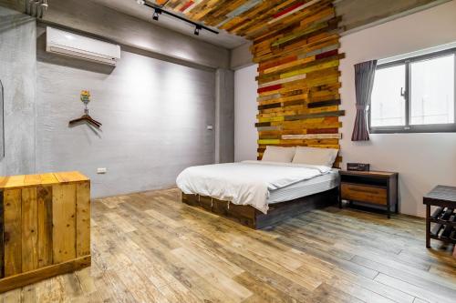 馬公市的住宿－鐘點棧民宿，一间卧室设有一张床和木墙