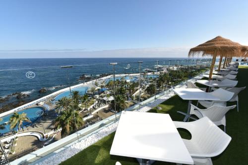 a row of tables and chairs on a balcony overlooking the ocean at Hotel Vallemar in Puerto de la Cruz