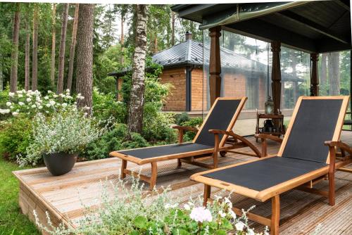 two chairs sitting on a deck in a garden at Villa Buta in Valmiera