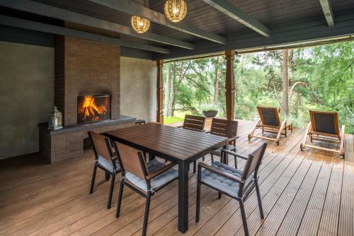 a dining room with a table and chairs and a fireplace at Villa Buta in Valmiera