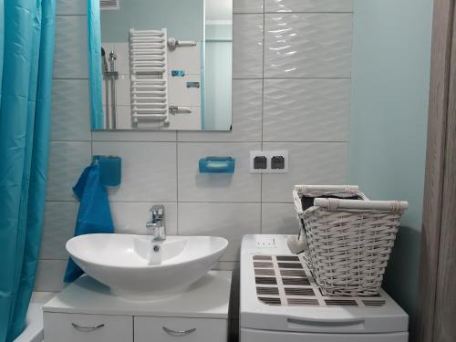 a white bathroom with a sink and a mirror at Apartamencik w centrum in Rumia