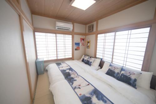 Habitación con cama grande en habitación con ventanas en Jomira &Jony House, en Tokio