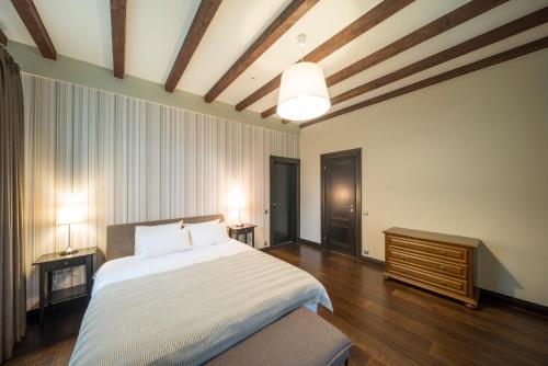 Schlafzimmer mit einem großen weißen Bett und Holzböden in der Unterkunft Villa Buta in Valmiera