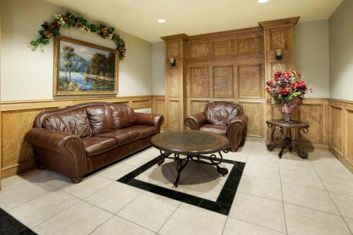 a living room with two leather chairs and a table at Holiday Inn Express Hotel & Suites Zapata by IHG in Zapata