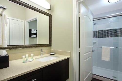 a bathroom with a sink and a mirror and a shower at Staybridge Suites - Houston - Medical Center by IHG in Houston