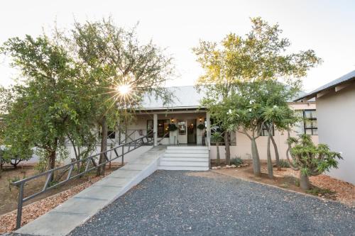 a house with a staircase leading to the front entrance at The Belgium Inn in Hoedspruit