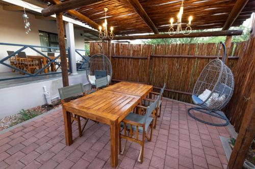 a wooden table and chairs on a patio at The Belgium Inn in Hoedspruit