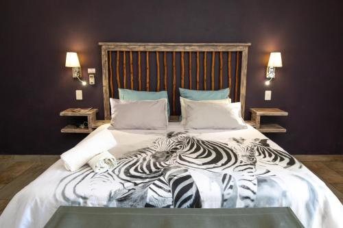 duas zebras deitadas numa cama num quarto em The Belgium Inn em Hoedspruit