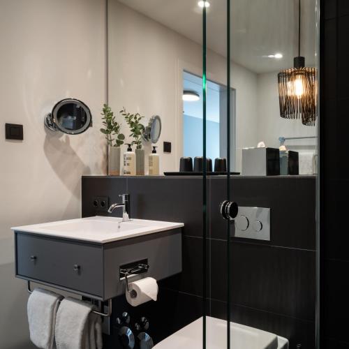 a bathroom with a sink and a mirror at Timehouse Serviced Apartments in Munich