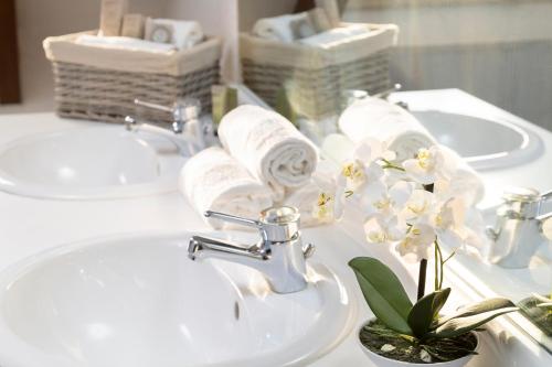 a bathroom with two sinks and towels on a counter at HÔTEL JEAN DE BRUGES in Saint-Riquier