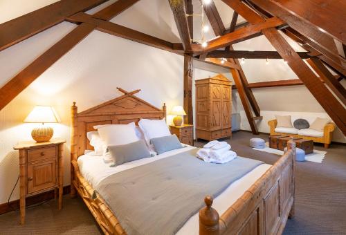 a bedroom with a large bed in a attic at HÔTEL JEAN DE BRUGES in Saint-Riquier