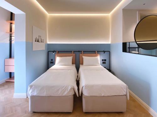 two beds sitting next to each other in a room at Iliria Boutique Hotel in Tirana