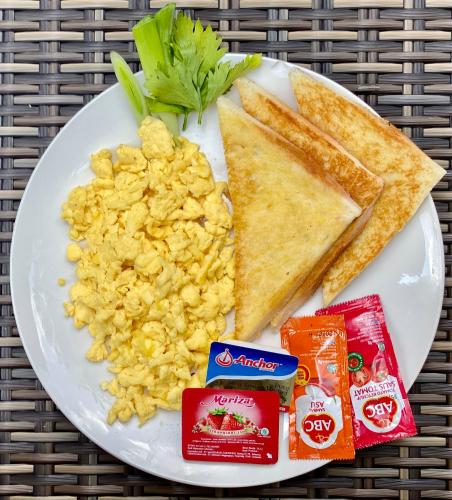 a plate of food with scrambled eggs and toast at Dugul Hidden in Ubud