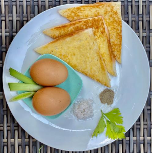 a plate with eggs and toast on a table at Dugul Hidden in Ubud