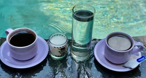 two cups of coffee and a glass of water at Dugul Hidden in Ubud
