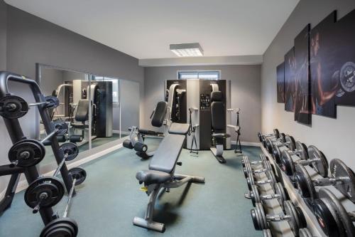 a gym with several treadmills and cardio machines at Leonardo London Heathrow Airport in Hillingdon