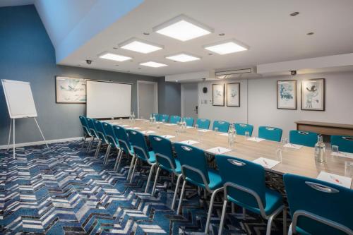 a large conference room with a long table and chairs at Leonardo London Heathrow Airport in Hillingdon