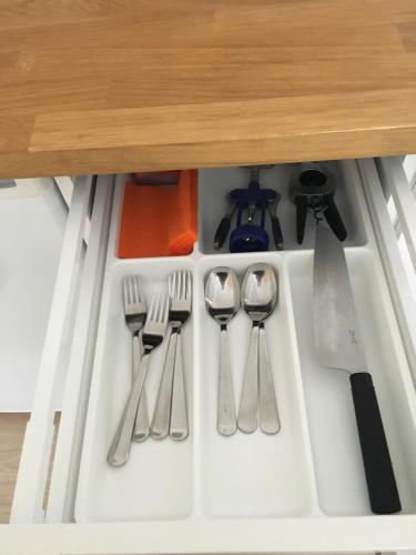 a drawer filled with utensils in a cabinet at Fox Apartments - Pie Lapsas in Priekuļi