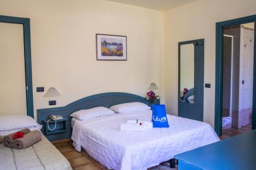 sypialnia z dużym łóżkiem z niebieskim zagłówkiem w obiekcie Futura Club Itaca Nausicaa w mieście Rossano
