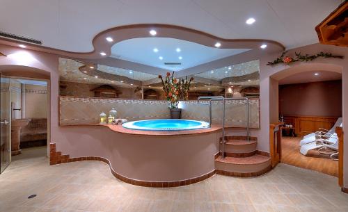 a large bathroom with a tub in the middle at Hotel Pejo in Peio Fonti