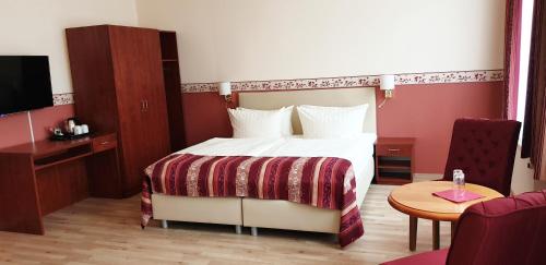 a hotel room with a bed and a table at Nordischer Hof in Krakow am See