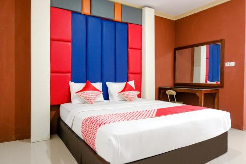 a bedroom with a large bed with a colorful headboard at OYO Life 2966 Hotel Atriaz in Trenggalek