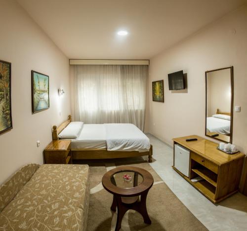 een kleine hotelkamer met een bed en een tafel bij B&B Passage in Sremska Mitrovica