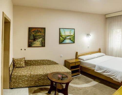 a hotel room with a bed and a couch at B&B Passage in Sremska Mitrovica