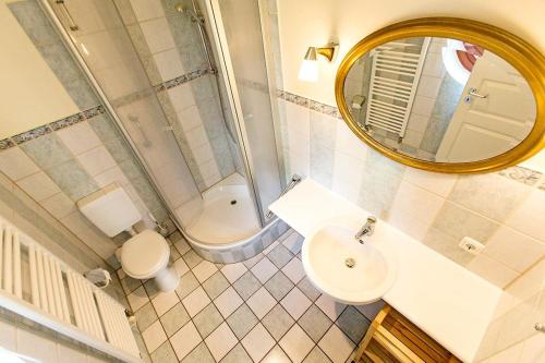 a bathroom with a sink and a toilet and a mirror at Ferienhaussiedlung Strandperlen Buchenhof 5a (Typ IV) in Wustrow