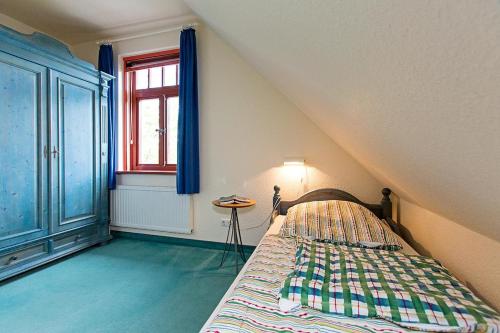 a bedroom with a bed and a window at Ferienhaussiedlung Strandperlen Buchenhof 5a (Typ IV) in Wustrow