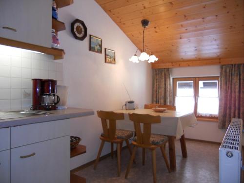 a kitchen with a table and chairs in a room at Urblhof in Leutasch