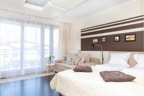 a bedroom with two beds and a couch at Apartamenty Villa Marea Misdroy by Renters in Międzyzdroje