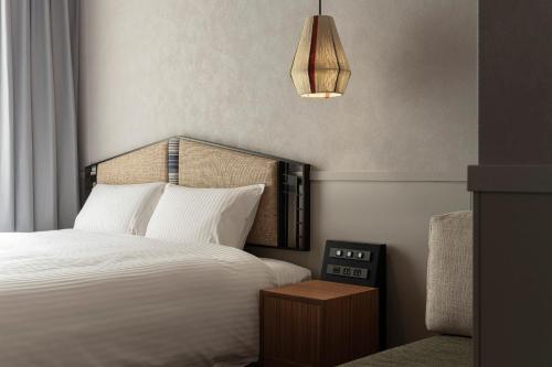a bedroom with a large white bed and a lamp at Hotel Aoka Kamigoto in Shinkamigoto